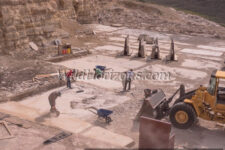 Overview of Green River Stone Company's fossil quarry near Kemmerer, Wyoming, USA. Staff are extracting fossiliferous slabs in the "18-inch layer," strata that have proven to contain the most fossils from this ancient lakebed that dates back to Eocene in the Green River Formation of southwestern Wyoming. Quarry Manager is Matt Helm, wearing a brown shirt, with three helpers: David Dilworth in green t-shirt; Dallin Ahrnsbrak in white t-shirt; and Jacob Benner in red t-shirt. Model releases available for all four.